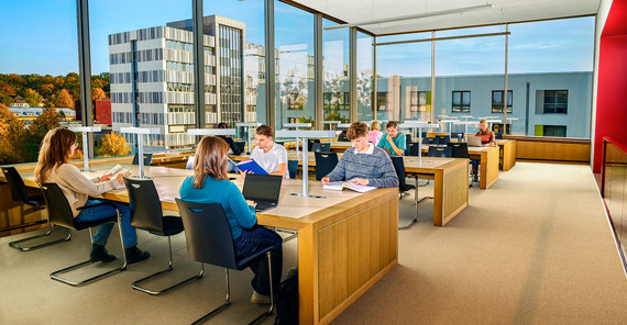 Studierende an Tischen im Lesesaal Golm vor Panoramafenster