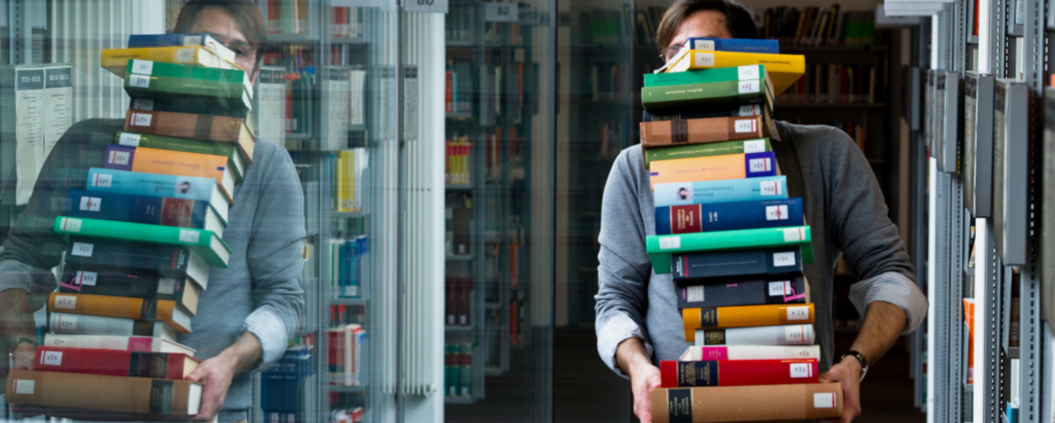 Person in library with loads of books - 