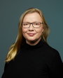 Heike Stadler, blonde lange Haare, Brille, schwarzes Oberteil